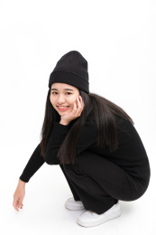 时尚女性手托下巴蹲着看镜头微笑