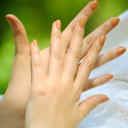 绿色背景上亚洲女人两只手手背互相交叉