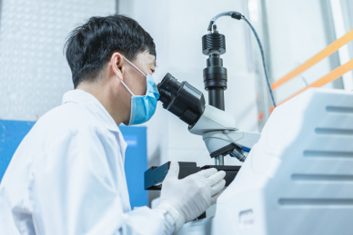 检验师正在使用显微镜检验样本