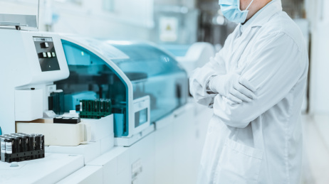 医务人员双手环抱站在医疗设备旁