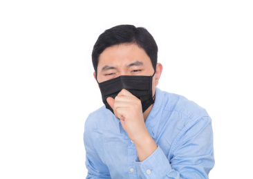 戴着口罩的男士在白背景前使劲干咳