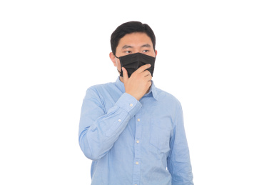 白背景前戴着口罩自我保护的男士