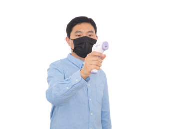 戴着口罩的男士手拿红外体温计