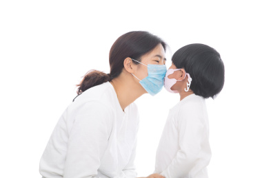 戴着口罩的妈妈在亲戴着口罩的女儿