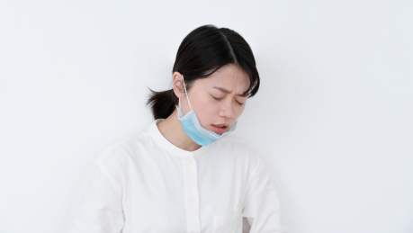 戴着口罩的女生很痛苦的喘气