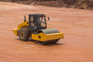 正在泥路上作业的压路机