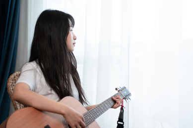 中国年轻女生在卧室弹吉他