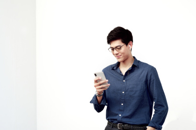 白背景前一位中国年轻商务男士在使用手机