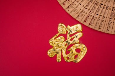 红色背景上的金色福字和扇子