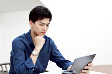 一位中国年轻商务男士在使用平板电脑