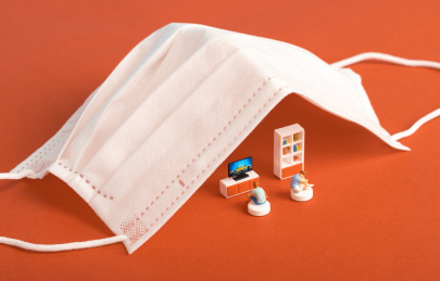 医用口罩下宅在家里看电视的青年男女