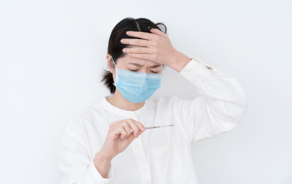 戴着蓝色一次性医用口罩的女生手拿体温计