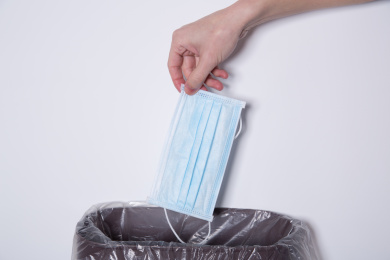 将未折叠的一次性口罩丢入垃圾桶的动作