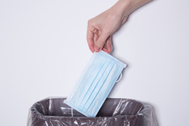 将未折叠的一次性口罩丢入垃圾桶的动作