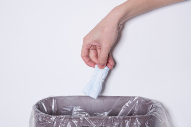 将折叠好的一次性口罩丢入垃圾桶的动作