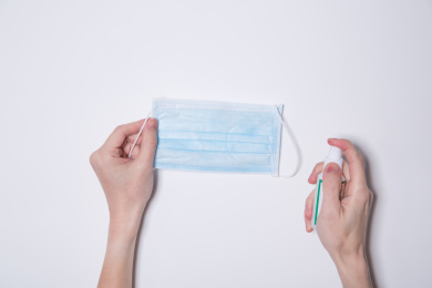 向一次性医护口罩喷洒酒精的动作