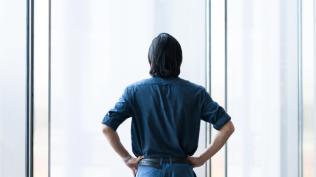 商务男士站在窗边打背影