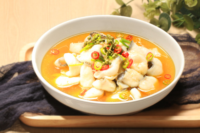 木托盘上白瓷碗中的藤椒鱼，配着蓝色餐巾