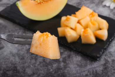 放在深色背景上盘子里切开的甜瓜果肉