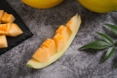 放在深色背景上切开的黄金甜瓜