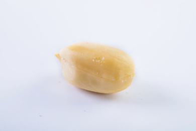 一颗剥皮的花生仁放在白色背景上