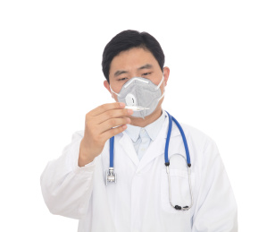 医院里戴口罩的男大夫在查看体温计