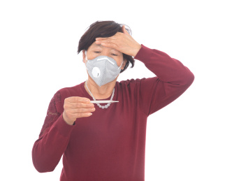 戴着口罩的女士在查看体温计上的数据