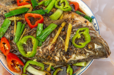 木桌背景中的一盘清蒸花雕鱼