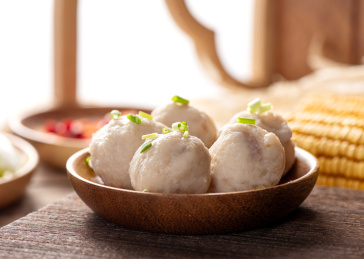 木纹背景上摆放的手打墨鱼丸