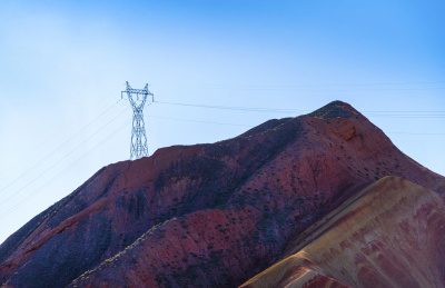 蓝天下的甘肃张掖七彩丹霞地貌中的发电电线