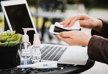 特写笔记本电脑前消毒手机