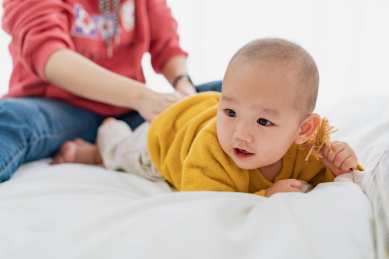 一个年轻的亚裔女性在为儿子换衣服