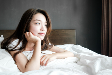 年轻的中国女孩趴在床上休息