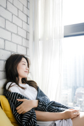 靠在窗边休息的年轻女孩