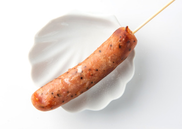 白色背景上摆放的火山石烤肠