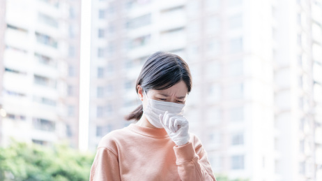 戴口罩戴女生在居民楼下咳嗽