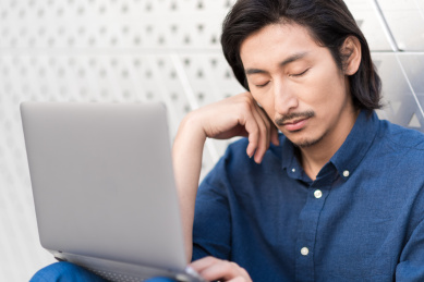 年轻商务男士使用便携式电脑疲劳的场景