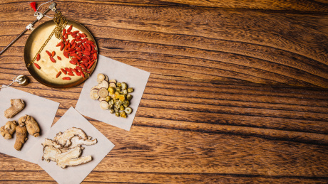 特写木桌上放着铜秤牛皮纸和中草药