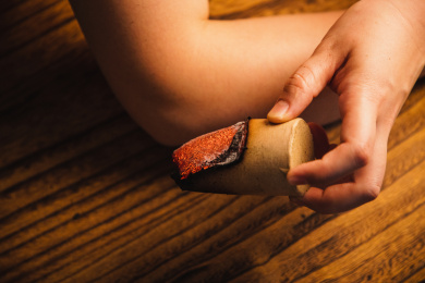 特写拿着点燃的艾灸条在灸手臂