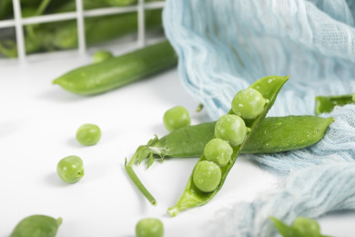 散落在白色桌子上的豌豆和豌豆荚