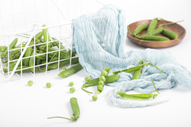 散落在白色桌子上的豌豆和豌豆荚