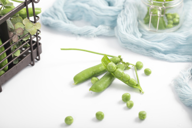 散落在白色桌子上的豌豆和豌豆荚