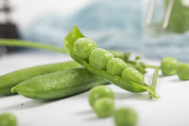 散落在白色桌子上的豌豆和豌豆荚