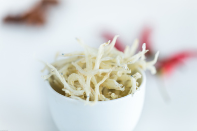 装在白色杯子中的小银鱼