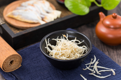 装在白色杯子中的小银鱼