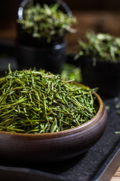 装在黑色碗里的中国茗茶竹叶青干茶叶