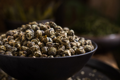 装在黑色碗里的茉莉龙珠干茶叶