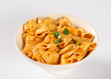 白色背景上餐具里盛放的红油面皮