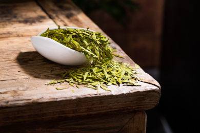 白瓷茶荷装着的龙井干茶叶