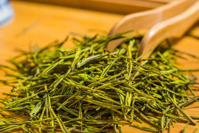 中国茗茶黄山毛峰干茶叶上放了干木夹